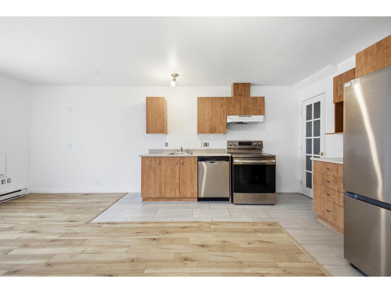 A kitchen with wooden floors and stainless steel appliances.