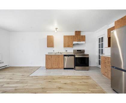 A kitchen with wooden floors and stainless steel appliances.
