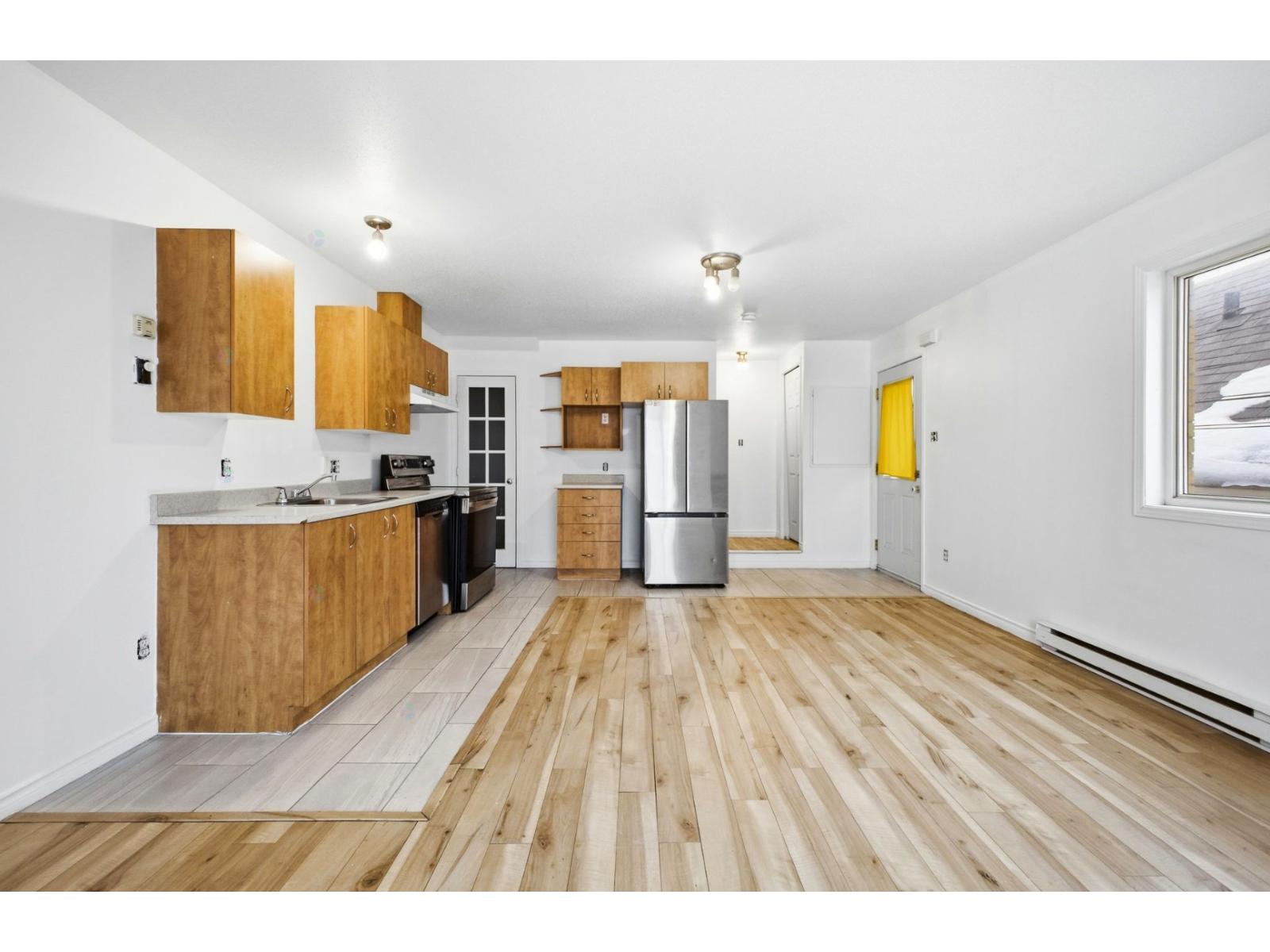 A kitchen with wooden floors and cabinets.