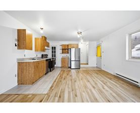 A kitchen with wooden floors and cabinets.