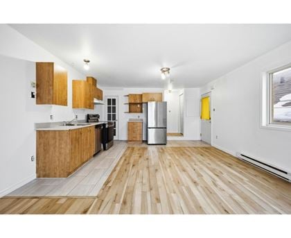 A kitchen with wooden floors and cabinets.