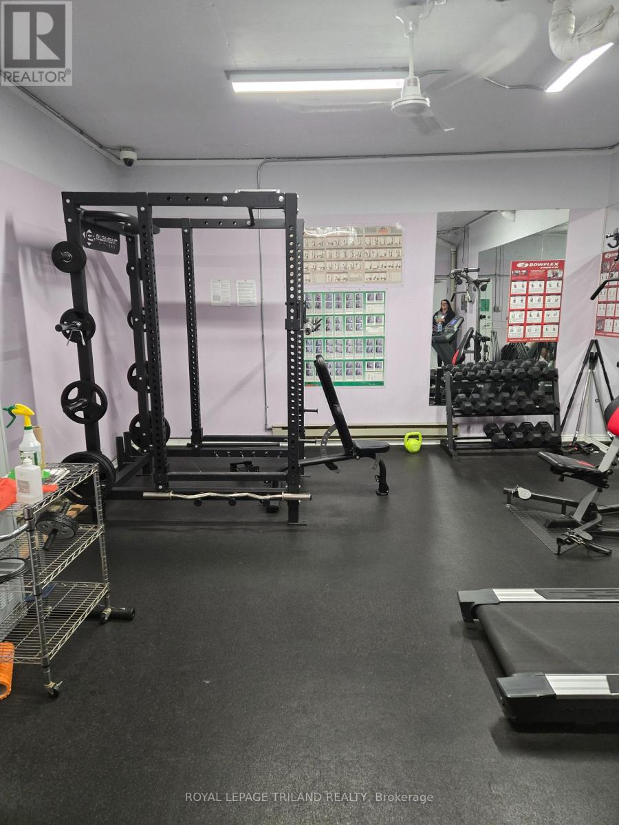 A gym with a squat rack, weight bench, and other equipment.