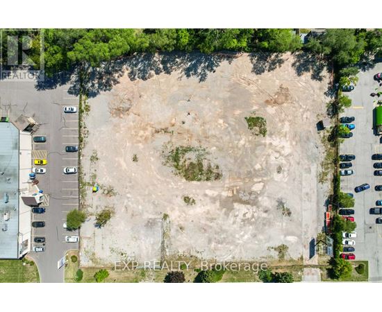 An aerial view of a parking lot with a large expanse of dirt in the center.