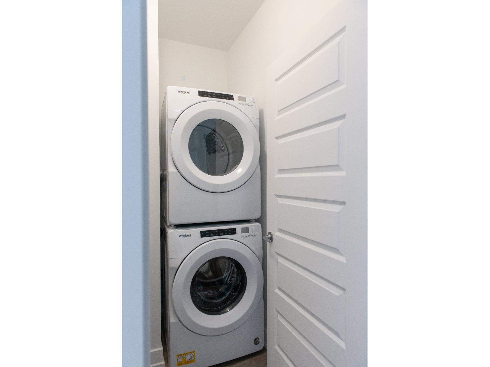 Two front loading washing machines in a small laundry room.