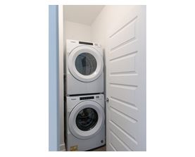 Two front loading washing machines in a small laundry room.