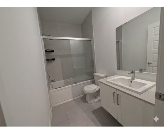 A white bathroom with a toilet, sink, and shower.