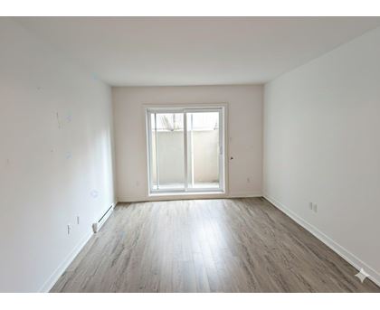 A room with a large window and wooden flooring.