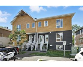 A two-story house with a garage and a car parked in front.