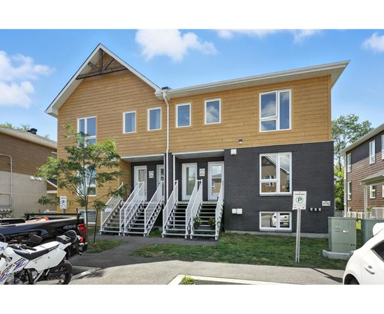 A two-story house with a garage and a car parked in front.