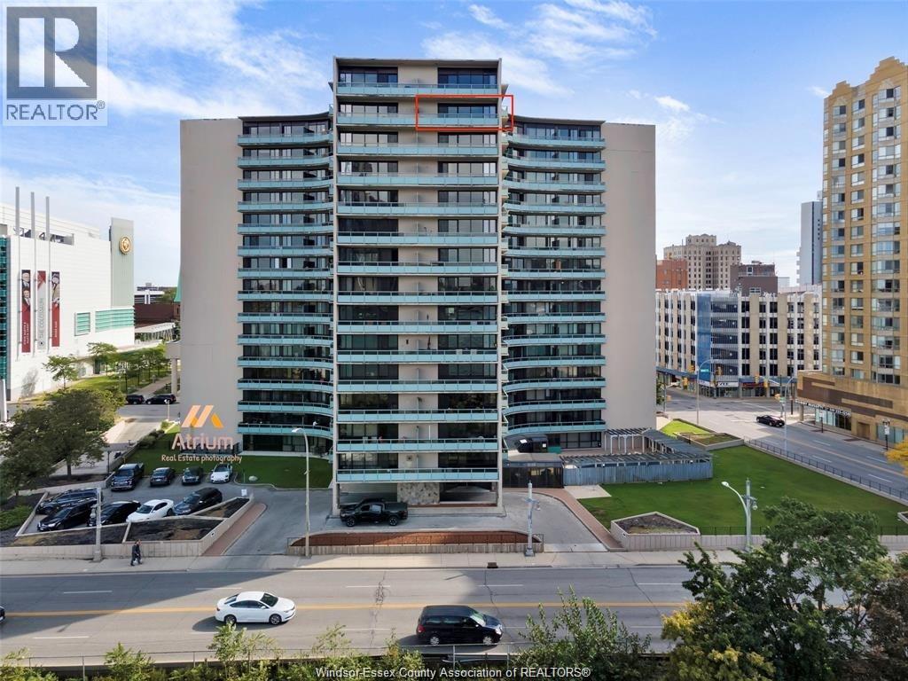 A tall building with a parking lot in front of it.