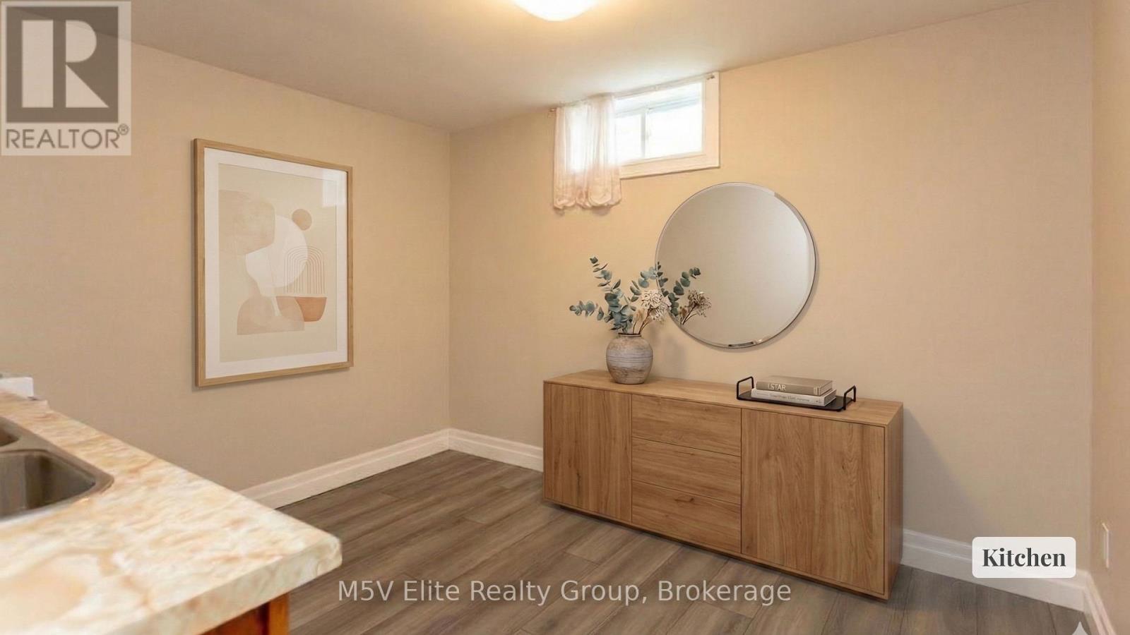 A kitchen with a sink, a mirror and a cabinet.