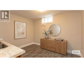 A kitchen with a sink, a mirror and a cabinet.