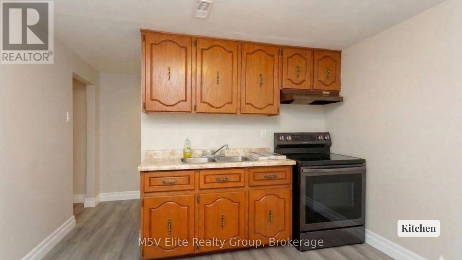 A kitchen with wooden cabinets and a black stove top oven.