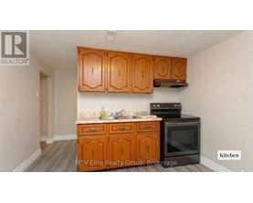 A kitchen with wooden cabinets and a black stove top oven.