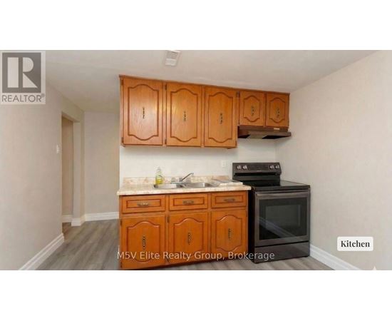 A kitchen with wooden cabinets and a black stove top oven.