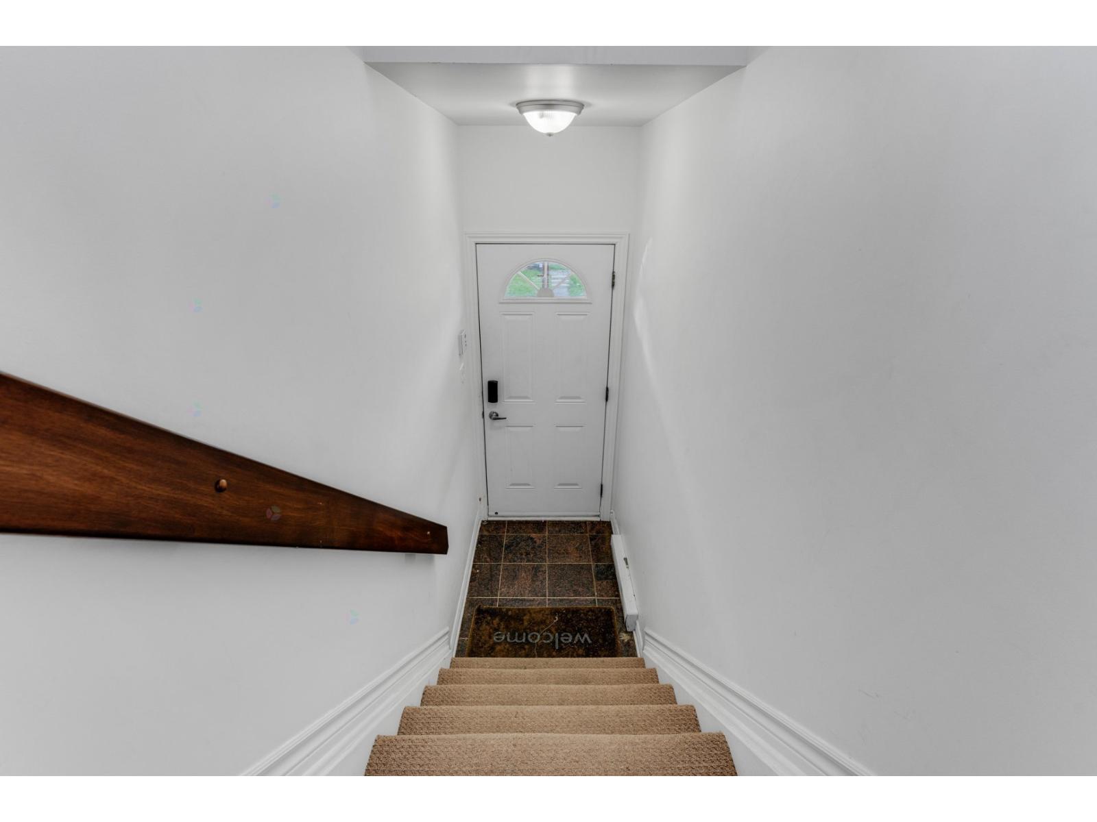 A staircase with a white door at the top.