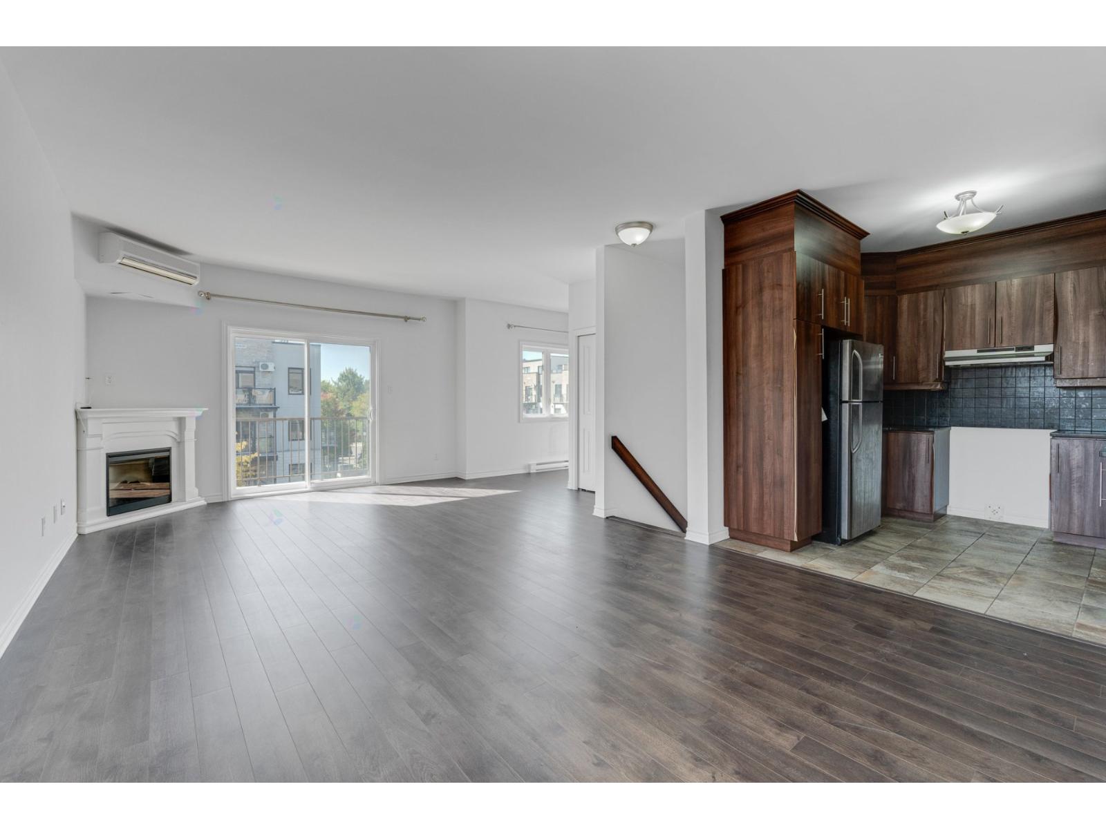 A spacious living room with a fireplace and sliding glass doors.