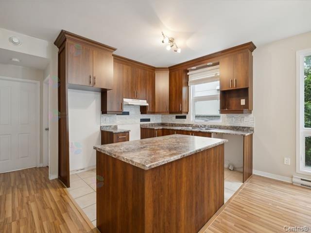 A kitchen with wooden cabinets and a marble countertop.