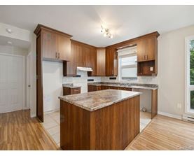 A kitchen with wooden cabinets and a marble countertop.