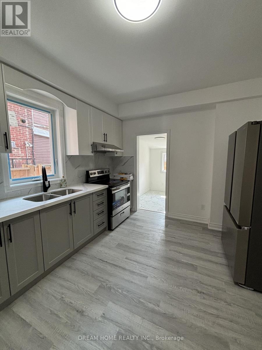 A kitchen with a sink, stove, and refrigerator.