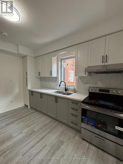A kitchen with a stove top oven and a sink.