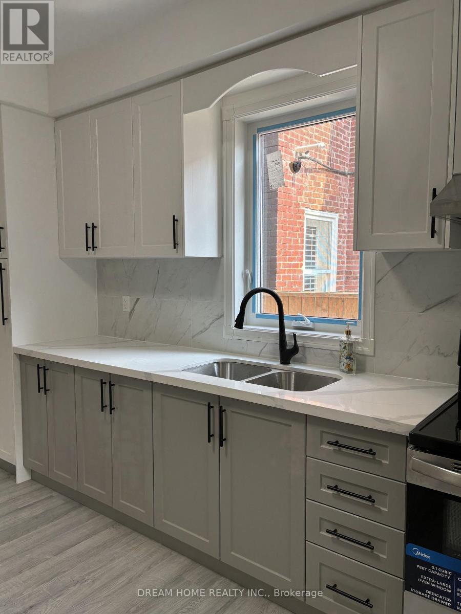 A kitchen with grey cabinets and a white countertop.