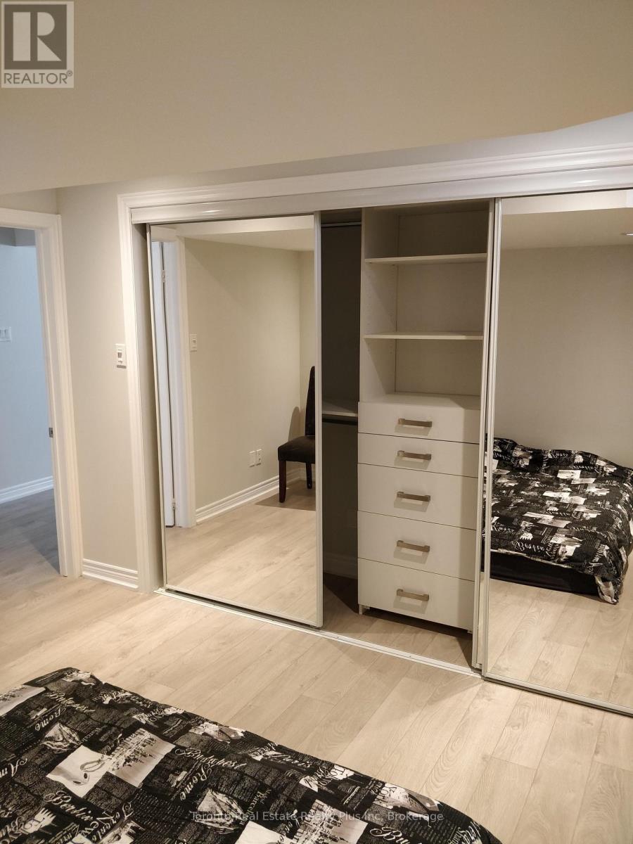A bedroom with a bed, chair, and wardrobe.
