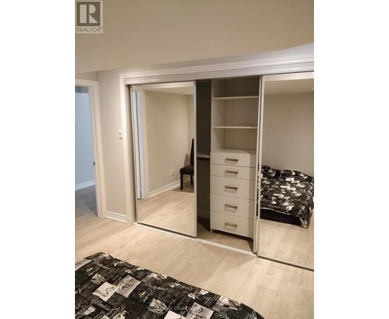 A bedroom with a bed, chair, and wardrobe.
