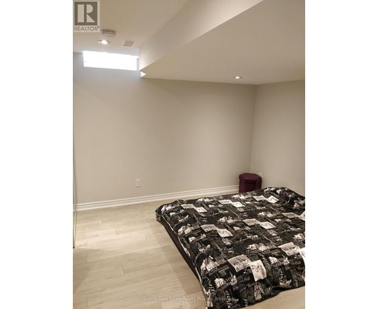 A bedroom with a bed and a red stool.