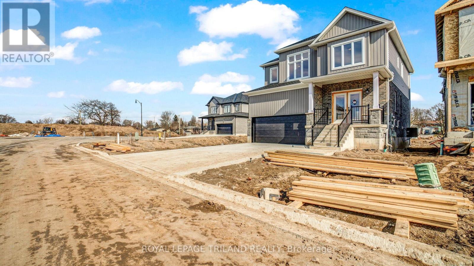 A construction site with a partially built house and a truck parked in front.