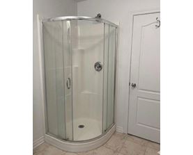 A glass shower stall with a white door.