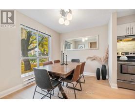 A dining room with a wooden table and chairs.