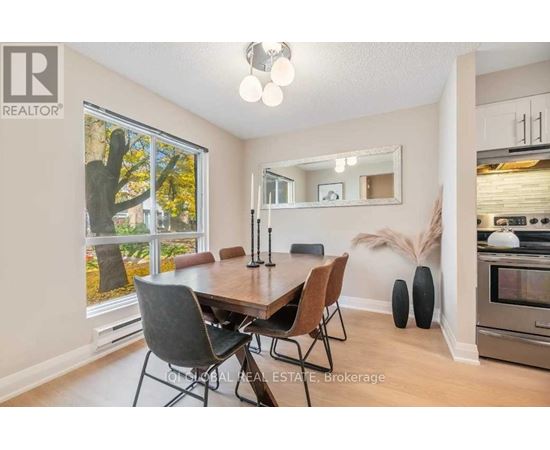 A dining room with a wooden table and chairs.