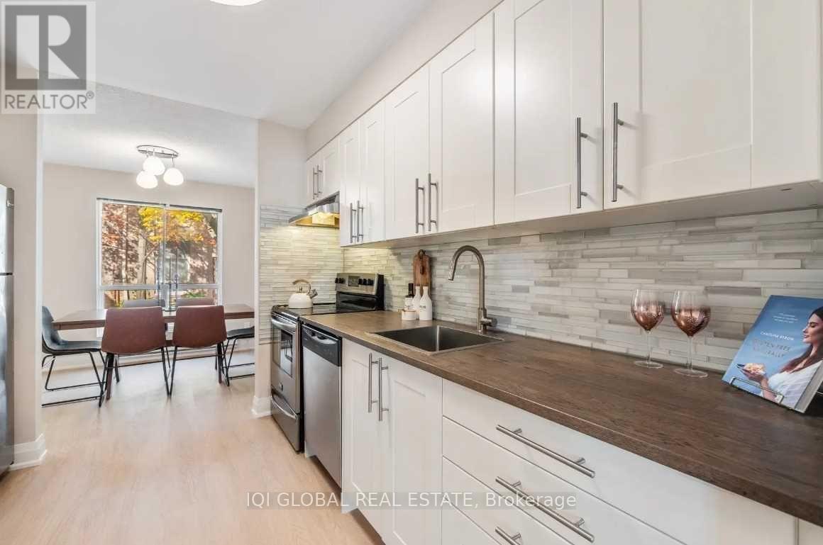 A modern kitchen with white cabinets and a wooden countertop.
