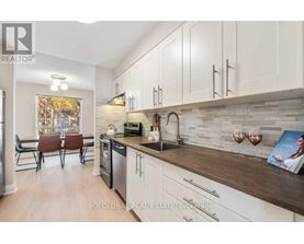 A modern kitchen with white cabinets and a wooden countertop.