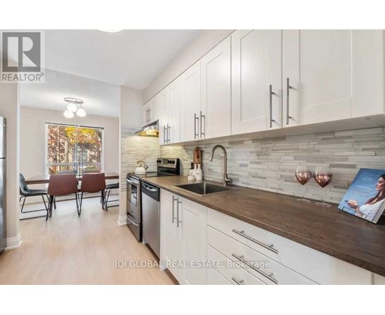 A modern kitchen with white cabinets and a wooden countertop.