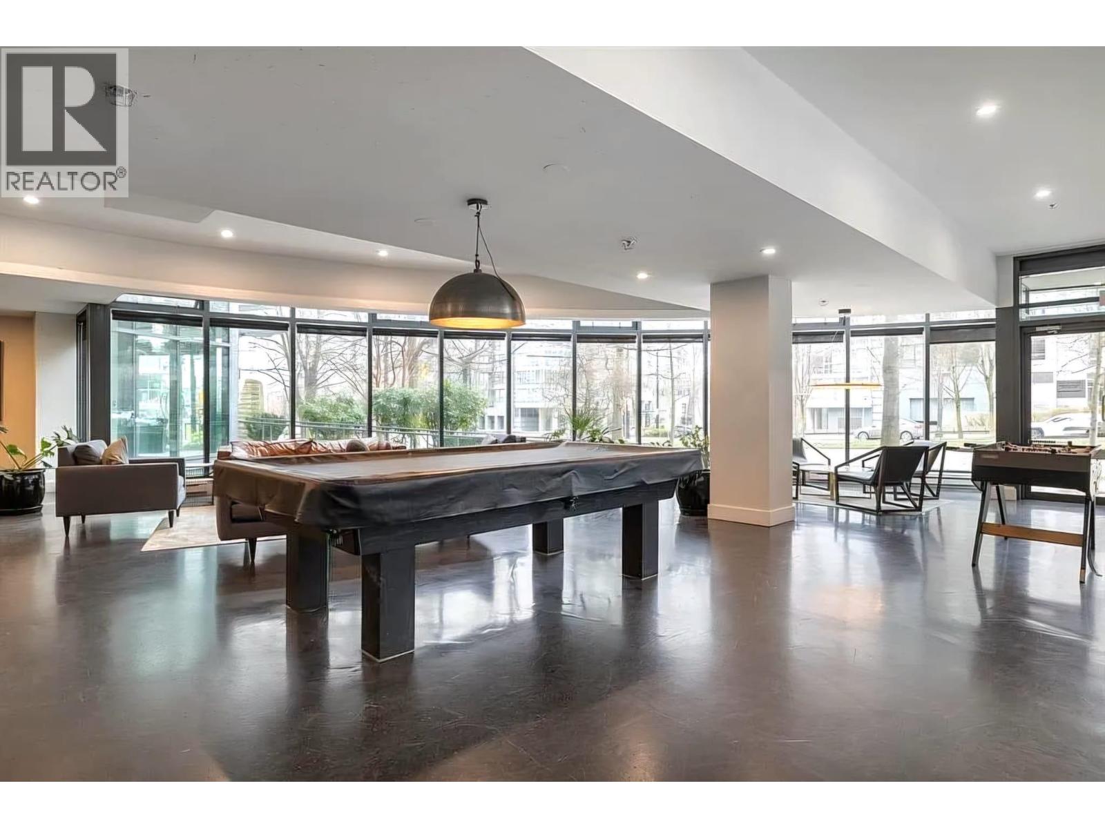 A spacious room with a pool table and comfortable seating.