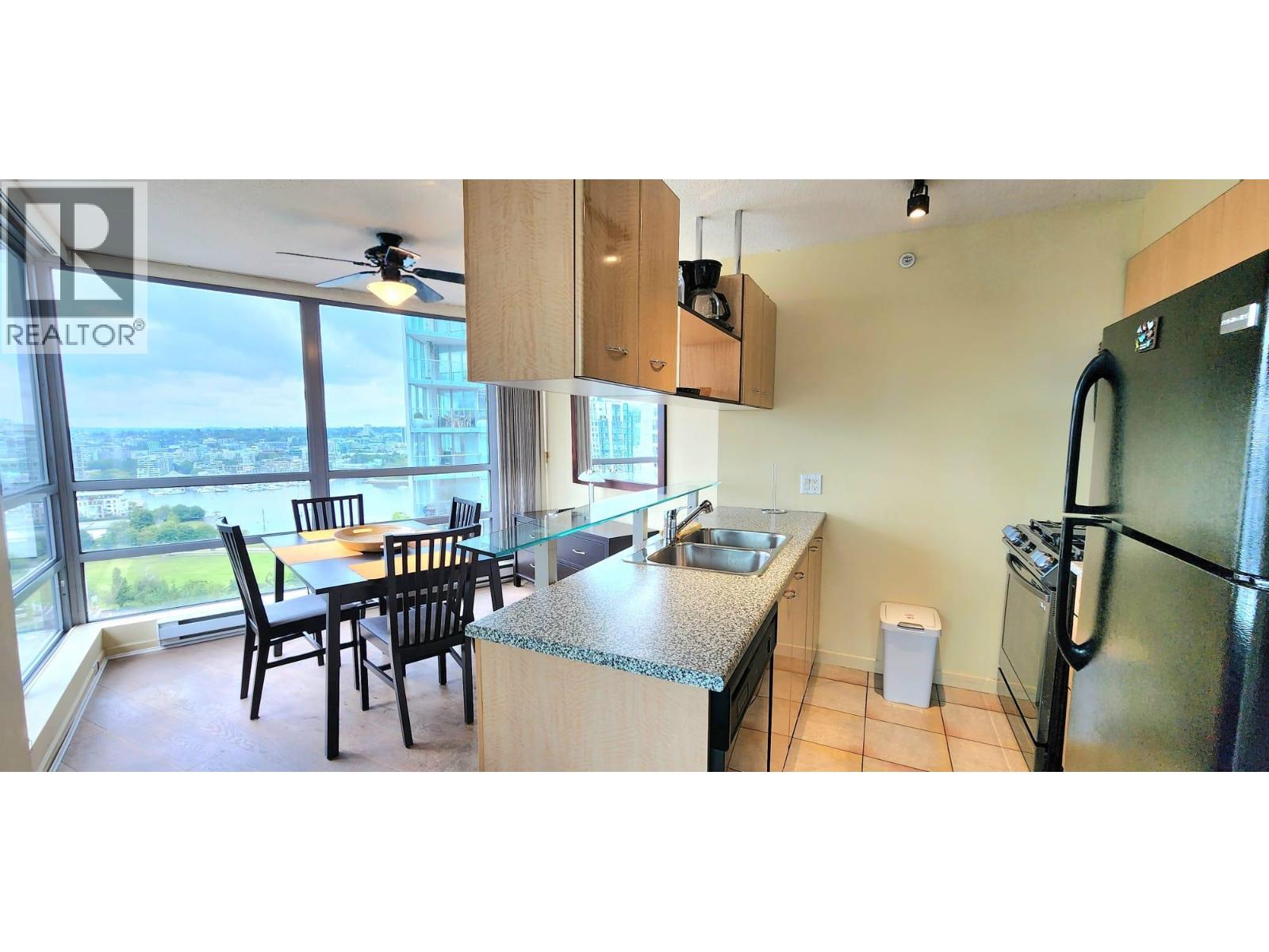 A kitchen with a table and chairs and a refrigerator.