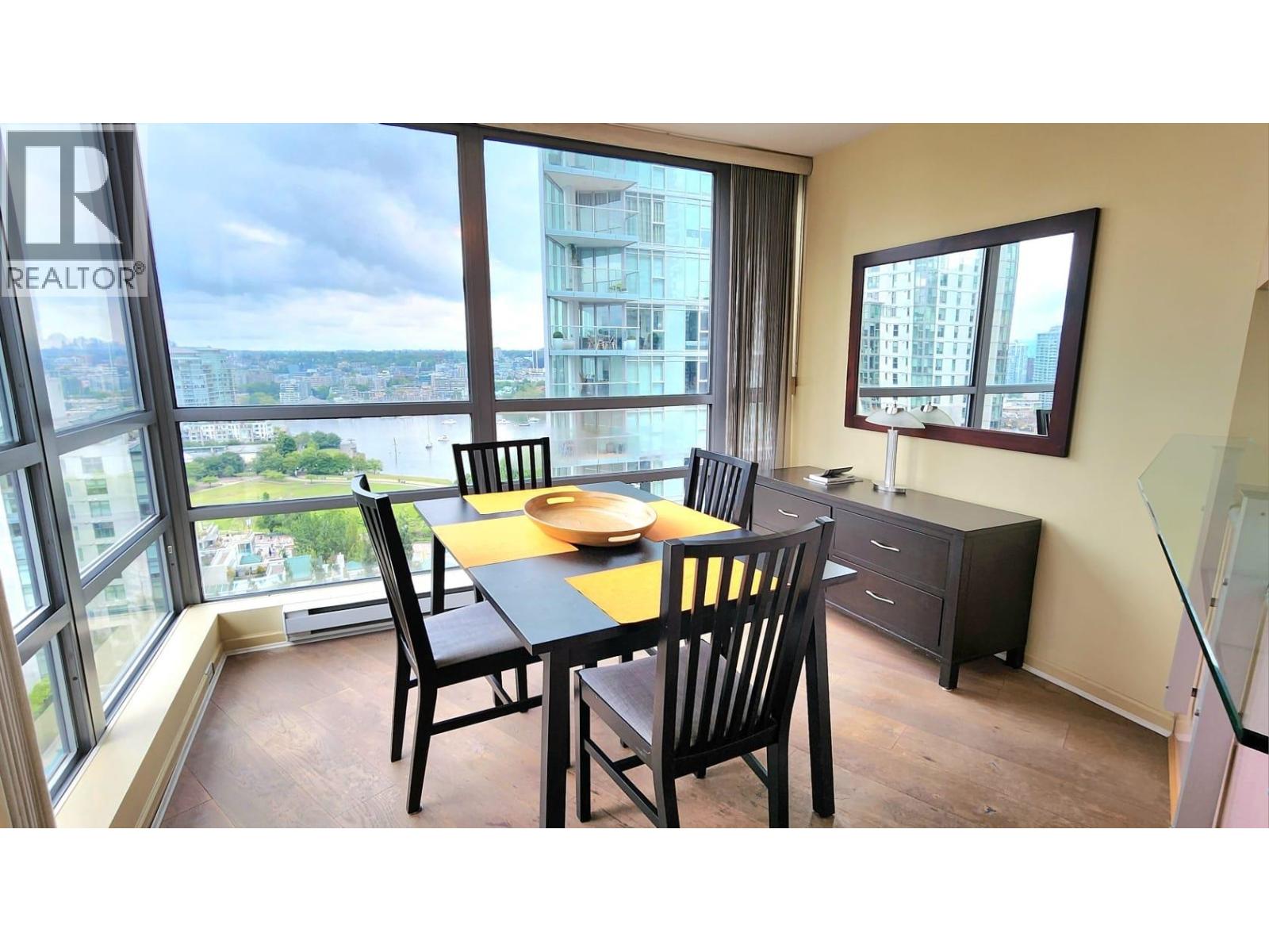 A dining room with a table set for two and a view of the city.