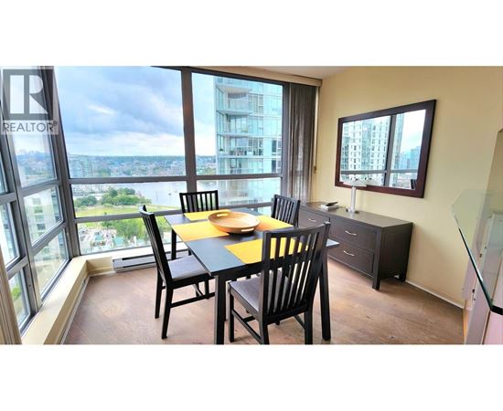 A dining room with a table set for two and a view of the city.
