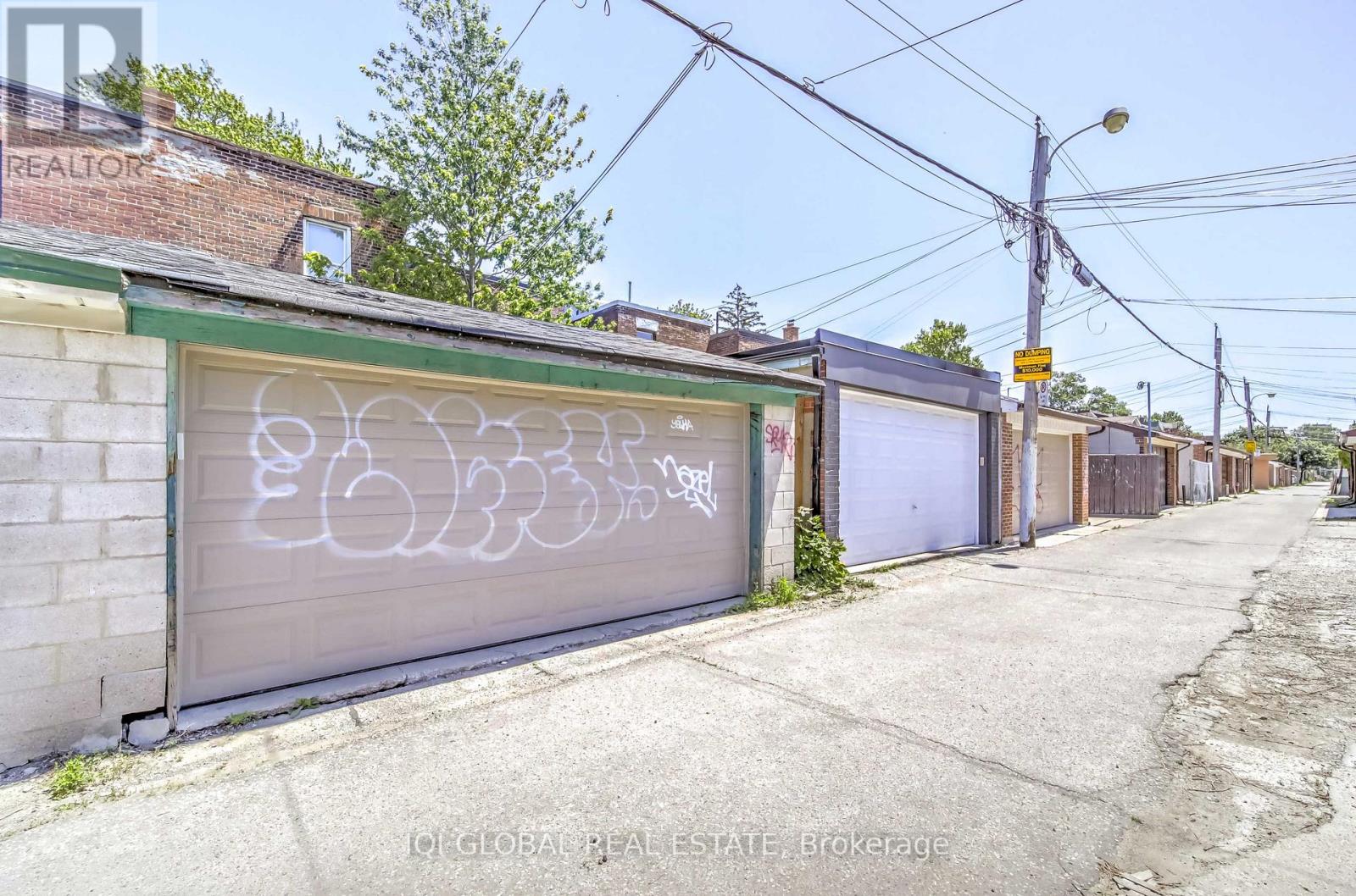 A row of garages with graffiti on the doors.