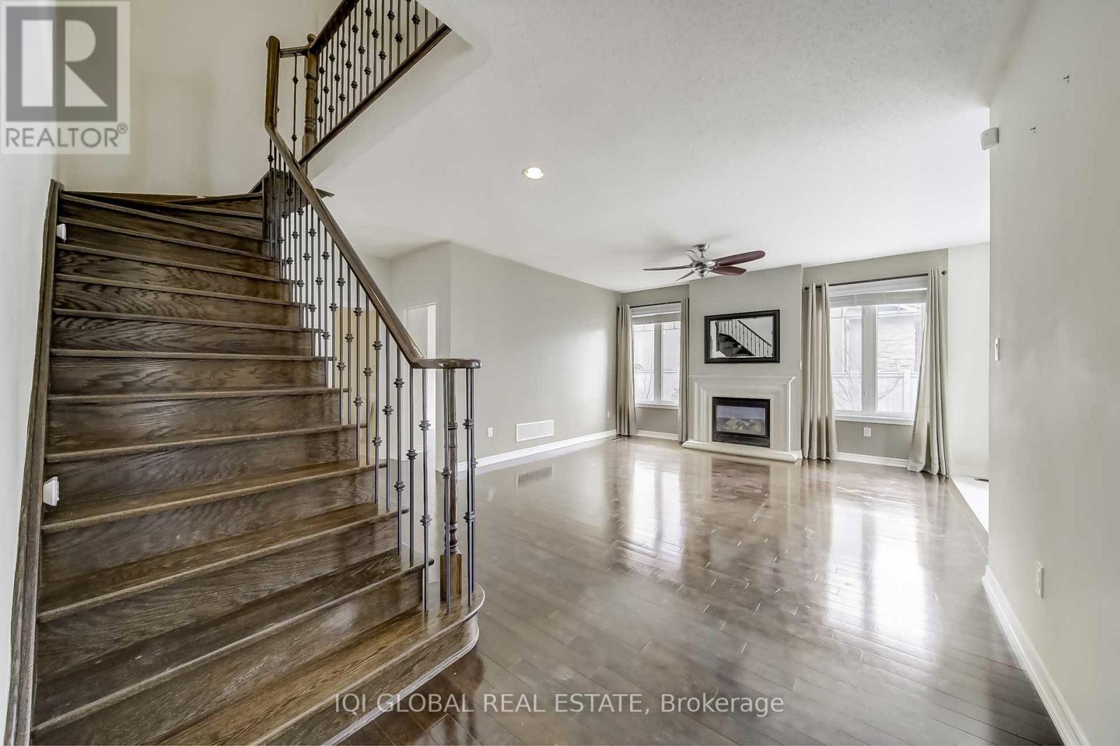 A spacious living room with a staircase leading to the upper floor.