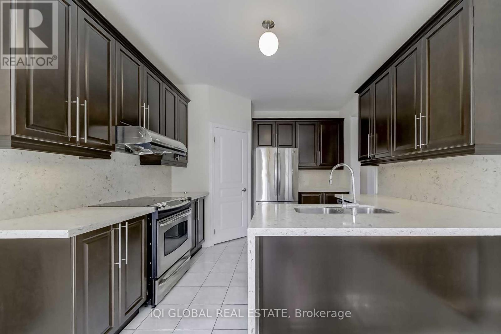 A kitchen with dark brown cabinets and stainless steel appliances.