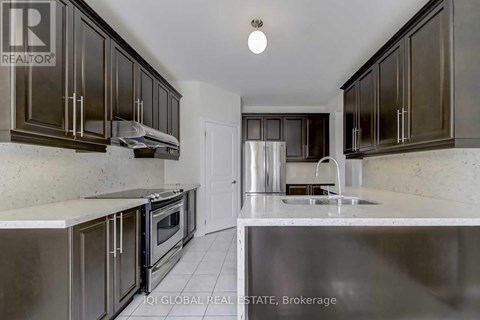 A kitchen with dark brown cabinets and stainless steel appliances.