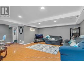 A living room with a television, couch, and rug.