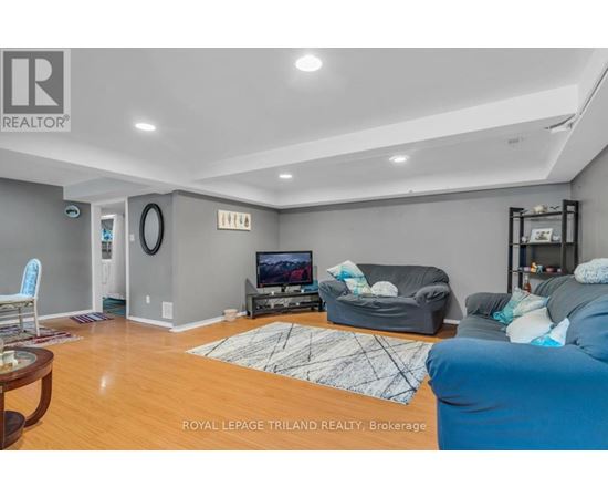 A living room with a television, couch, and rug.