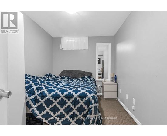 A bedroom with a bed, nightstand, and lamp.