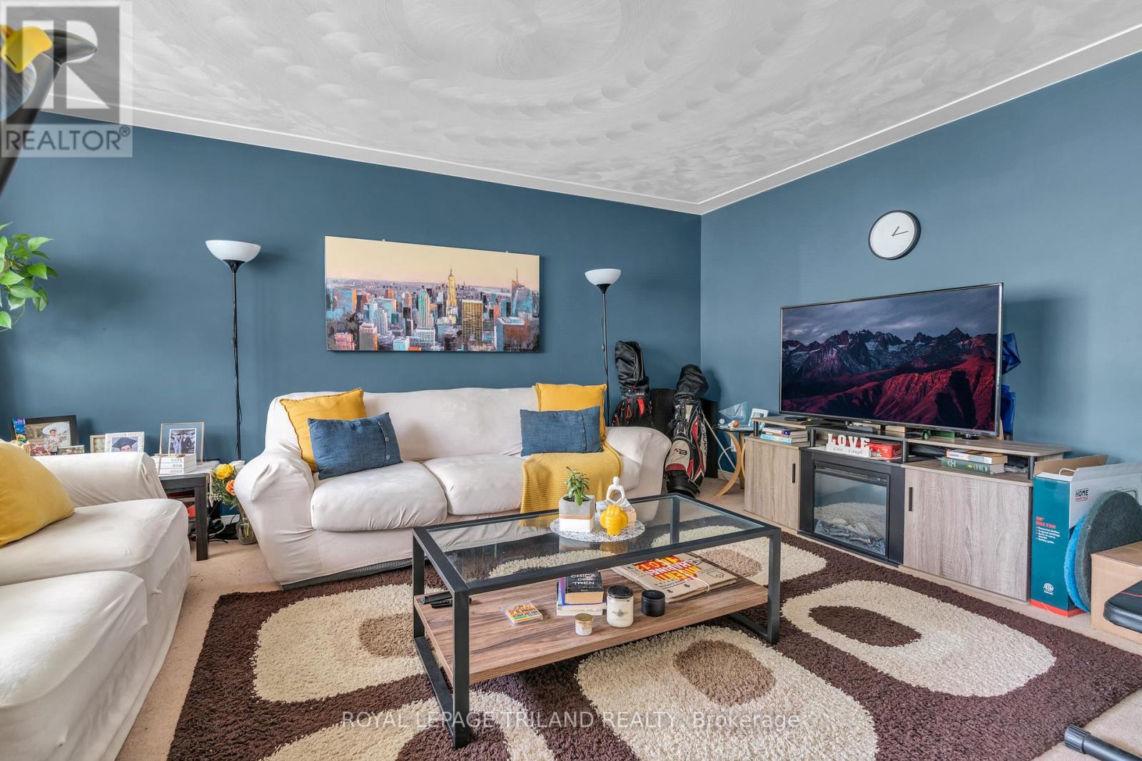 A living room with a white couch, a coffee table, and a flat screen TV.