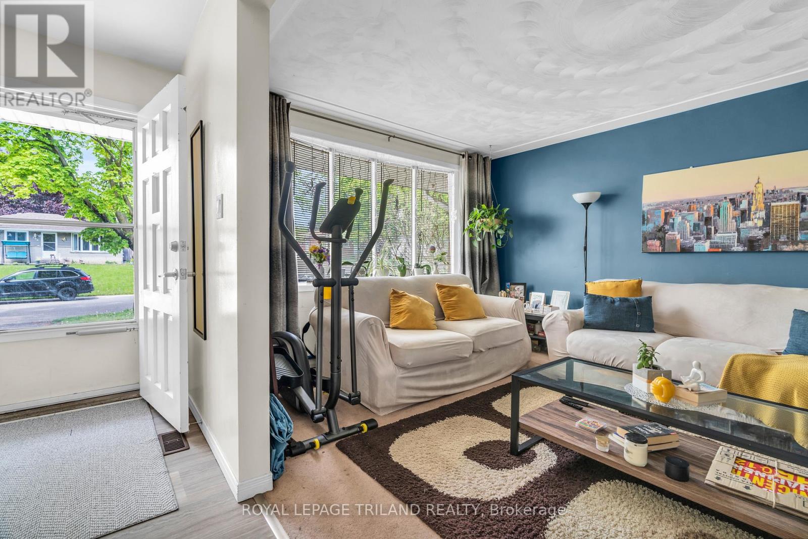 A living room with a white couch and a glass coffee table.
