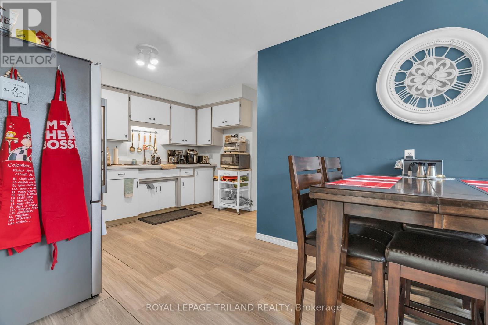 A kitchen with a blue wall and a wooden table.